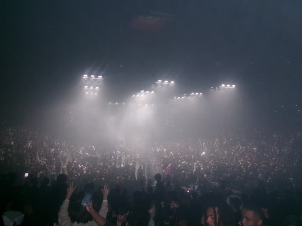 Crowd at an indoor concert under bright stage lights