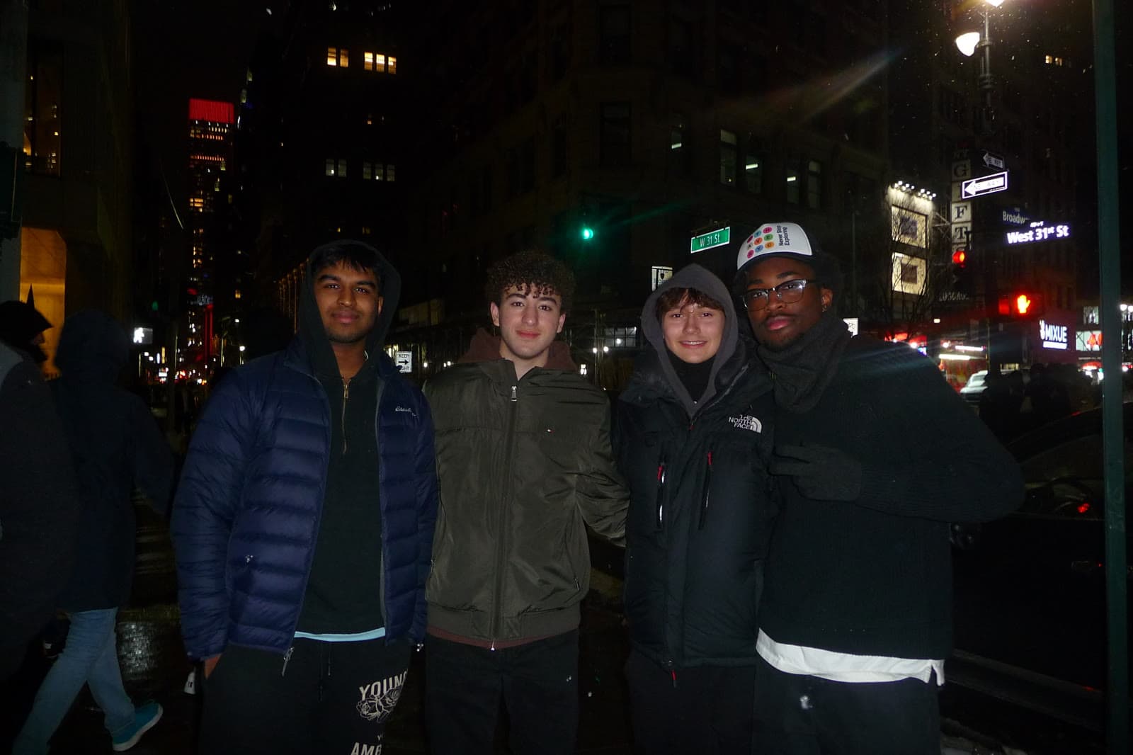 Four friends on a New York street corner at night