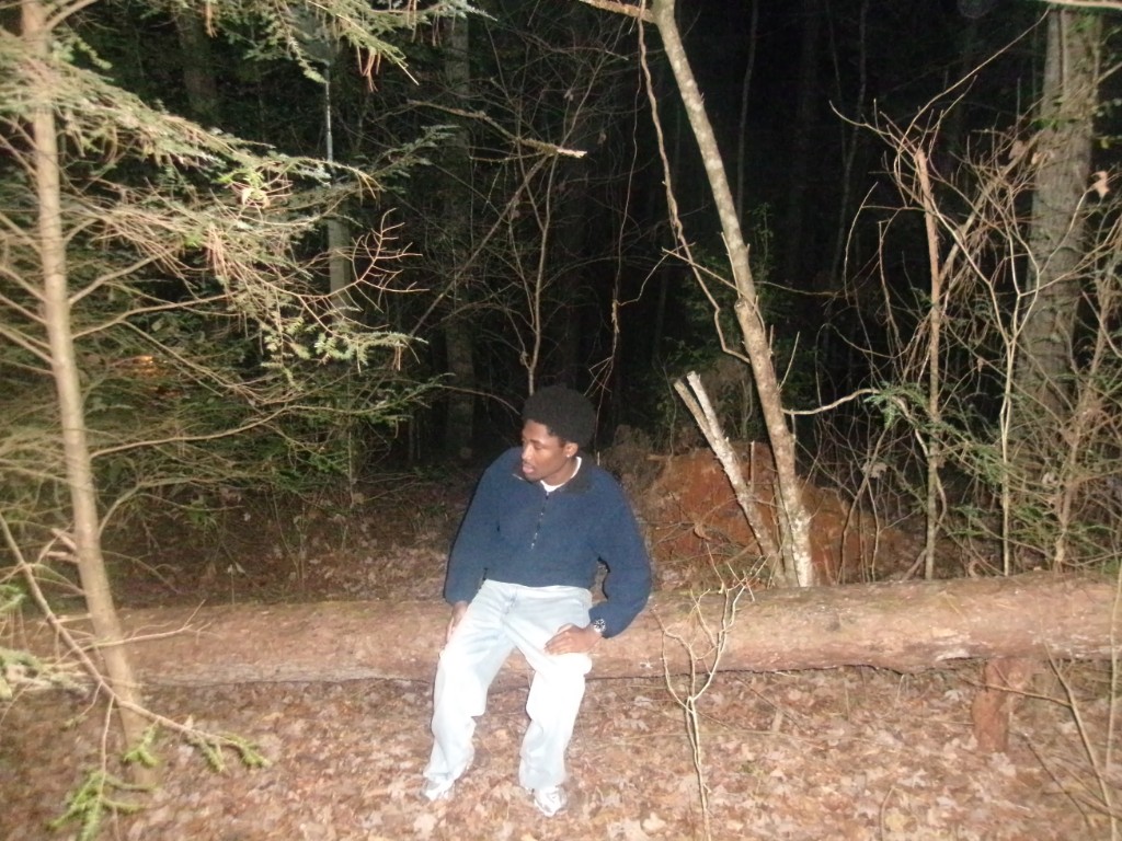 Sitting on a fallen log in the woods at night