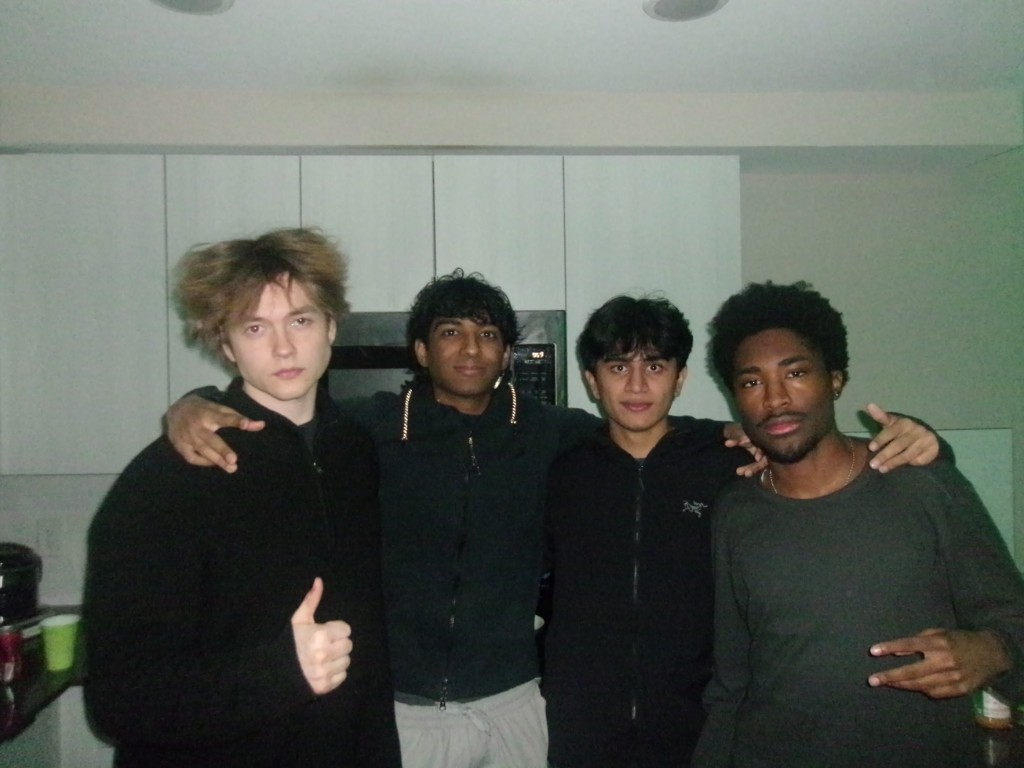 Four friends posing in a kitchen