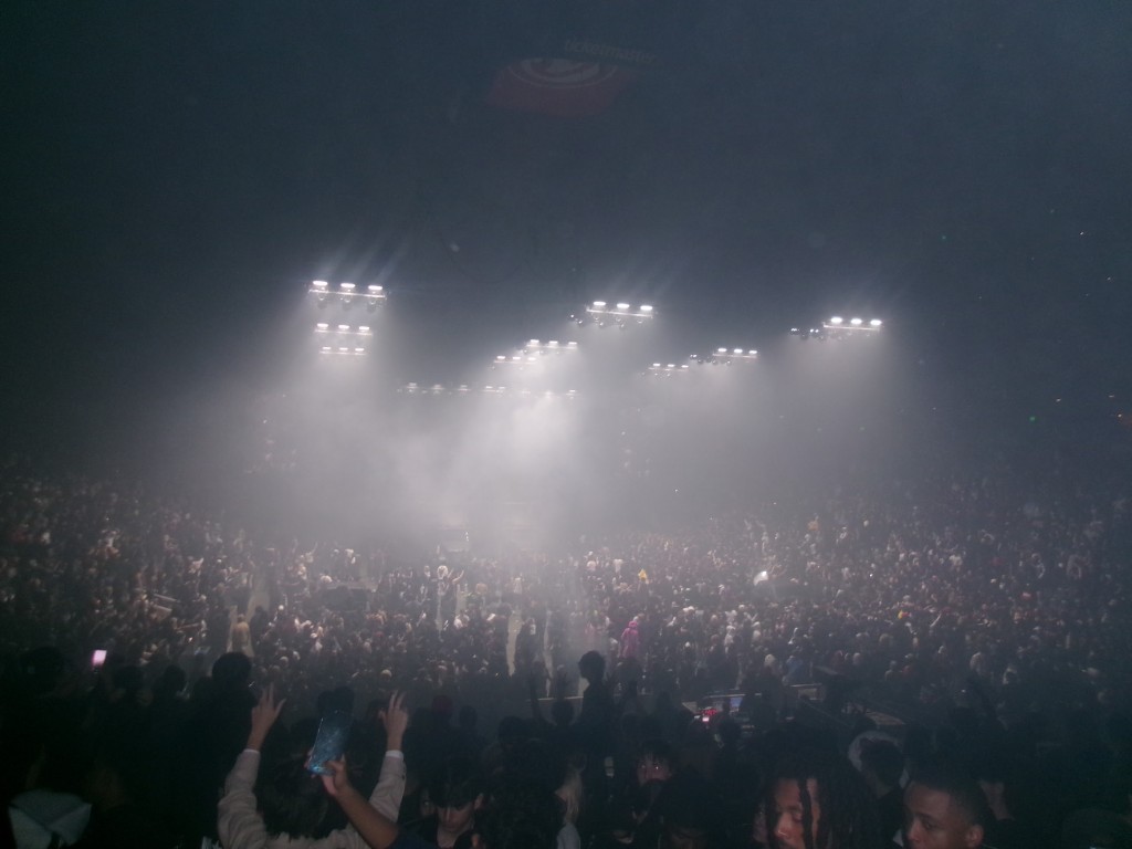 Crowd at an indoor concert under bright stage lights